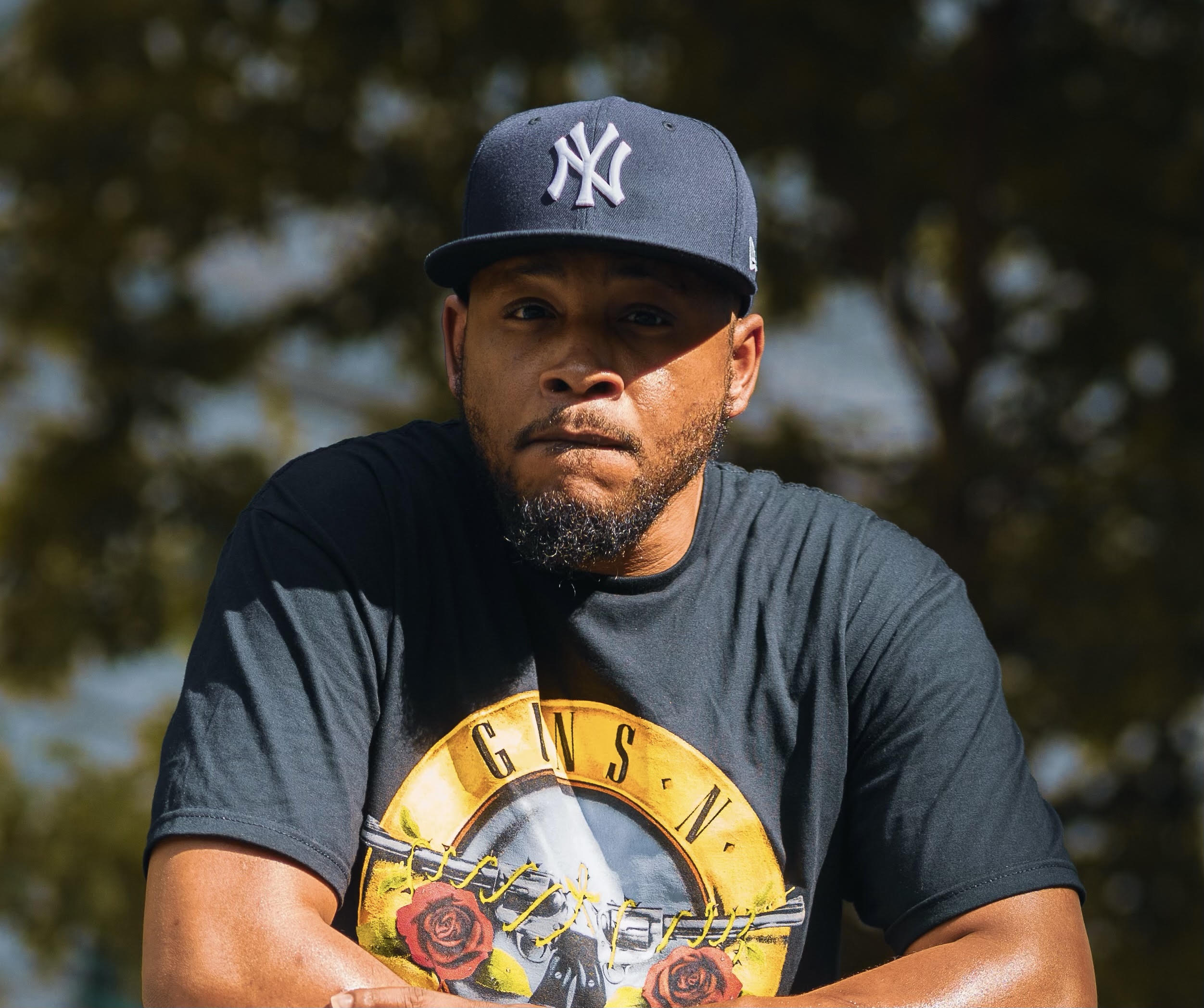 IntenT outdoors wearing a Yankees cap and a Guns N’ Roses shirt