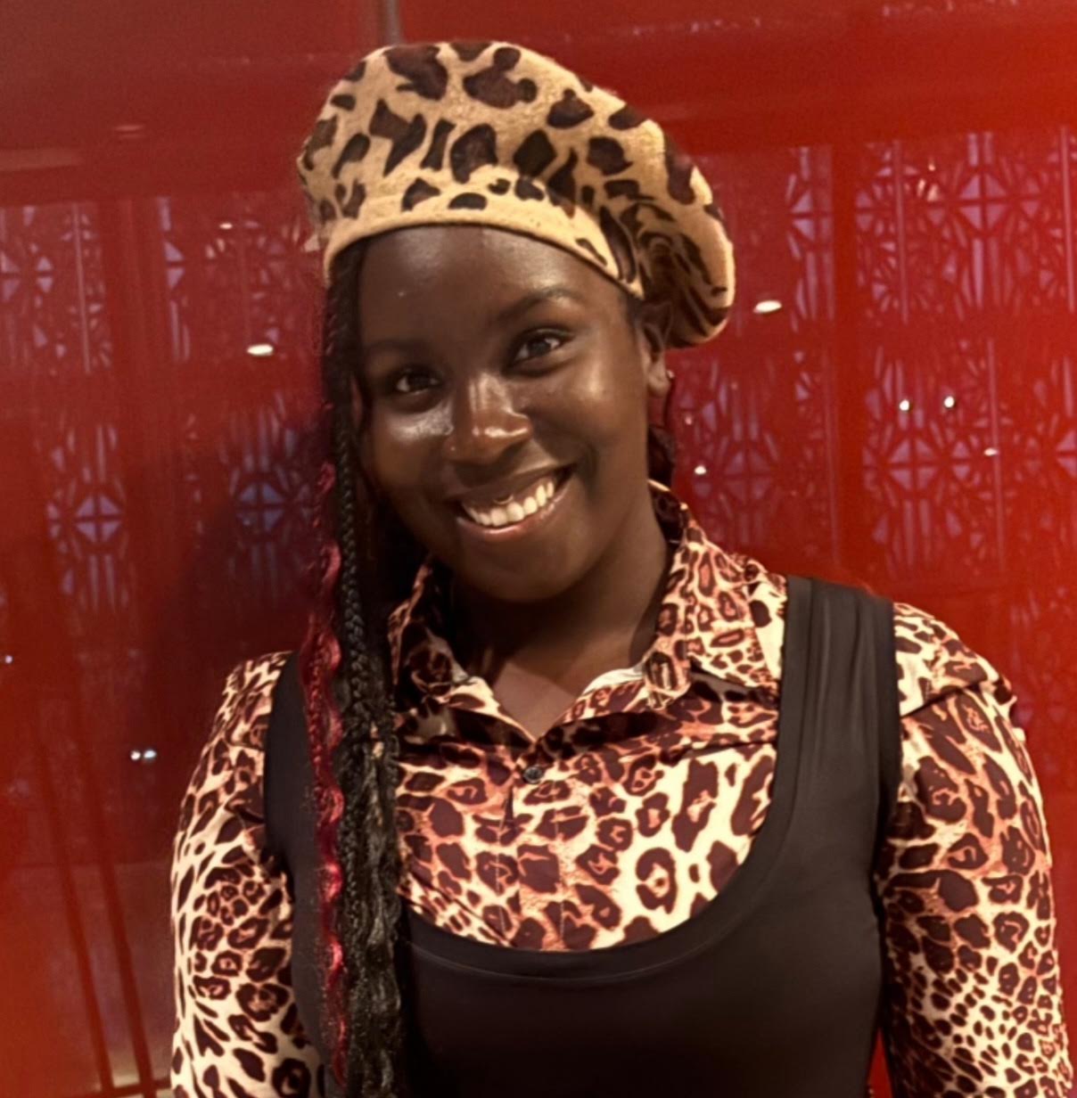 TAZ smiling in a leopard-print hat and shirt